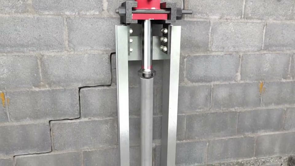 Dalinghaus Foundation Repair installing push piers with a hydraulic ram, for bowing concrete block walls with a stair-step